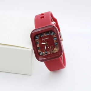 Detail view of square burgundy quartz watch with swan motif and silicone strap
