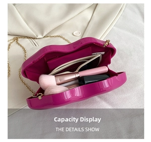 Lip-shaped acrylic box clutch bag showing interior capacity and golden chain strap