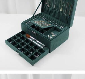 Detailed view of dark green velvet jewelry box with drawers and necklace hooks