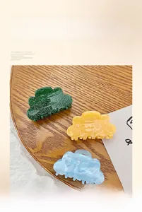 Three cloud-shaped acrylic hair claws in green, yellow, and blue marble patterns