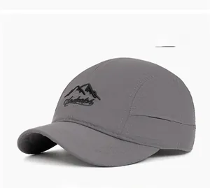 Detail of gray quick-dry baseball cap featuring mountain embroidery and short brim