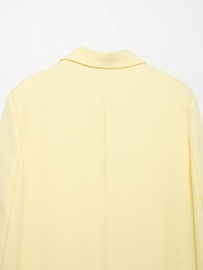 Detailed back view of light yellow blazer showing neckline and shoulder fabric texture