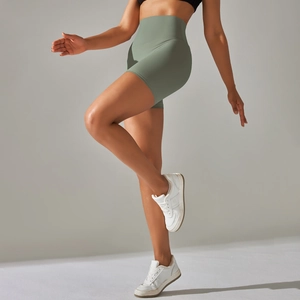 Detail of high-waisted sage green yoga shorts showing seamless texture and peach lift fit