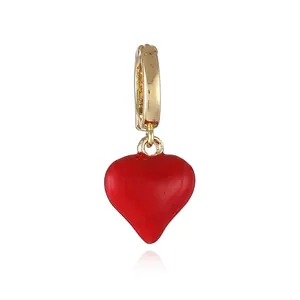 Detailed macro of 18k gold plated earring with a polished red heart pendant charm