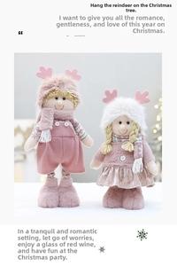 Close-up of pink plush Christmas dolls with reindeer antlers and grey plaid scarves