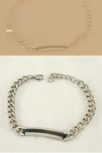 Détail du bracelet chaîne plat avec plaque rectangulaire noire et fermoir mousqueton robuste