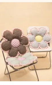Detailed view of floral plush cushions with plaid center and fuzzy trim on chairs