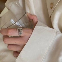 Detailaufnahme eines silbernen Totenkopf-Handrings an einem Glas mit edler Ästhetik