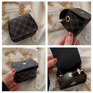 Detail view of mini brown crossbody bag with gold chain strap and magnetic flap