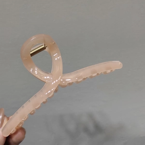 Detail showing high-quality gold metal spring on a translucent jelly pink hair claw clip