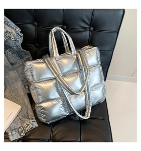 Vista ravvicinata della borsa trapuntata argento metallizzato su una sedia nera