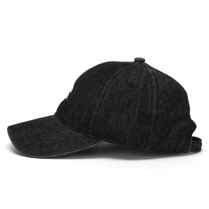 Side profile of black denim baseball cap with curved brim and washed texture