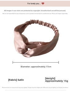 Close-up of champagne satin headband showing the twisted cross design and elastic band detail