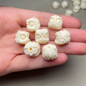 Macro view of ivory-white lion dance beads made from tagua nut on a person's hand