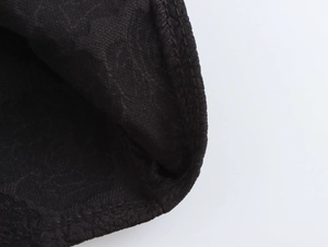 Detaillierte Nahaufnahme der schwarzen Jacquard-Stoffstruktur und Präzisionsnähte am Kleid