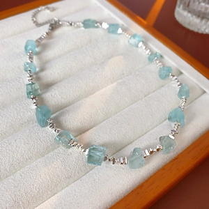 Dettaglio della collana con pietre preziose azzurre e perline d'argento in vassoio