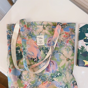 Close-up of a floral cotton tote bag featuring abstract oil painting prints and a chic label