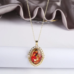 Dettaglio del ciondolo Madonna dorata con zirconi e catena sottile della collana