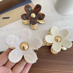 Elegant floral hair claws in tortoise shell and pearl white with golden center accents