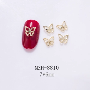 Detail view of 7x6mm mini hollow golden butterfly alloy charms on red nail tips
