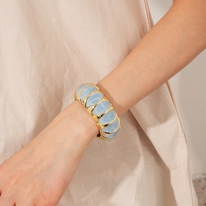Close-up of a vintage elastic bracelet featuring blue resin and gold metal diamond shapes