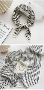 Detailed view of black and white pleated scarf with artistic line drawing pattern