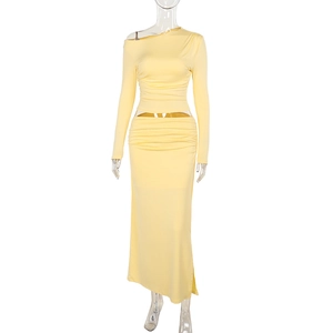 Detail of light yellow off-shoulder long sleeve top and slim pleated maxi skirt set