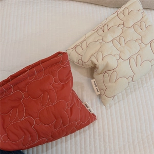 Detailed view of quilted cotton cosmetic bags featuring cute rabbit embroidery patterns