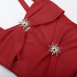 Close-up of deep red dress fabric with golden sun-shaped metal decorative buttons