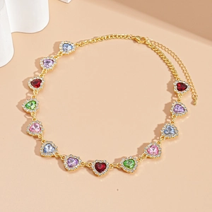 Détail du collier doré orné de pierres précieuses multicolores en cœur et de cristaux brillants