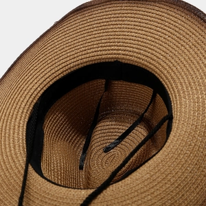 Detailed macro view of the inner spiral weave and adjustable black strap on the straw hat