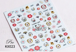 Macro shot of 5D nail art stickers with lucky cat, cherry blossoms, and red fans