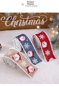 Detailed view of plush burlap Christmas ribbons with Santa and snowflake patterns on snow