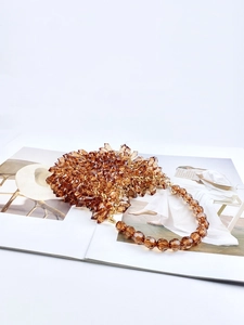 Close-up of amber beaded handbag featuring faceted acrylic crystals and golden chain strap