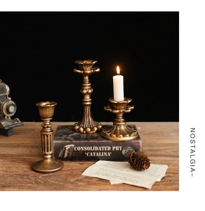 Dettagli di candelabri vintage in metallo bronzo con trama a rilievo su tavolo scuro