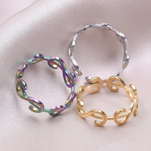 Minimalist stainless steel open rings in gold, silver, and rainbow colors on silk fabric