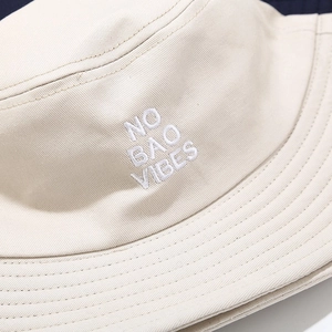 Cotton bucket hat in beige with white 'NO BAO VIBES' embroidery and stitched brim