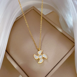 Macro detail of a gold windmill necklace with zircon stones in a luxury jewelry box