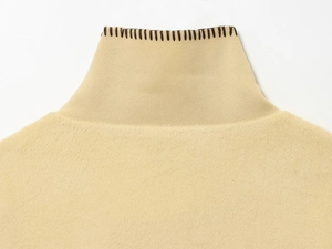 Macro view of knit collar stitching and premium beige wool fabric texture on the jacket