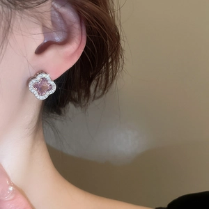 Detail of luxury clover stud earrings with pink zircon and sparkling silver plating