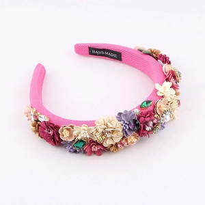 Detail of pink baroque sponge headband with colorful fabric flowers and faux gemstones