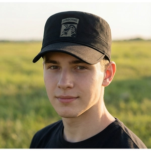 Close-up of black flat top military cap featuring an Airborne eagle patch in outdoors