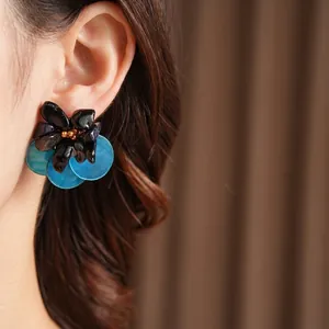 Vintage floral shell earrings with black and blue petals and gold bead centers
