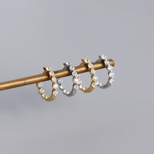 Détail macro de créoles en argent S925 or et argent avec sertissage de zircons brillants