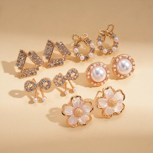 Detail view of 6-pair gold earring set with rhinestones, pearls and bowknot designs