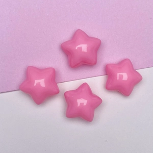 Flat lay of four glossy pink macaron star resin charms for DIY craft making