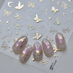 Detail of gold butterfly nail stickers with stars and moon designs for manicure