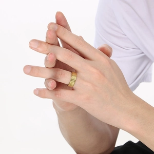 Close-up of golden stainless steel ring with honeycomb texture on a male hand