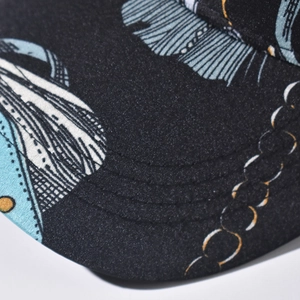 Close-up of black baseball cap with blue and gold patterns showing high-quality stitching