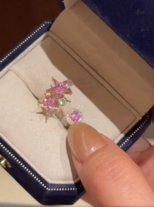 Detail of rose gold open ring featuring pink star zircons and a purple round gemstone
